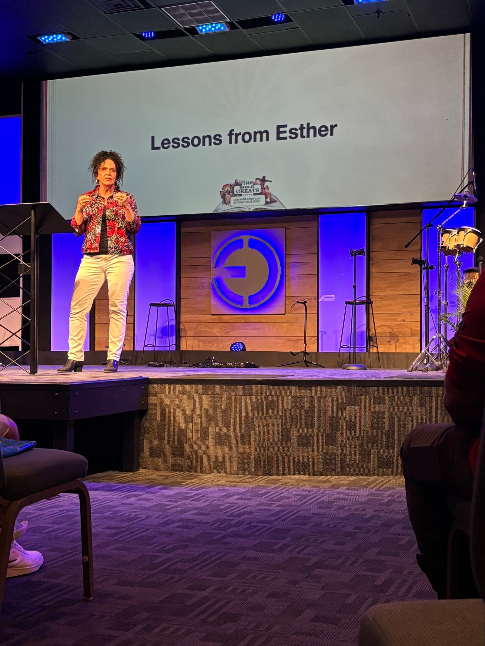 Melody speaking on stage at a church event, teaching Lessons from Esther